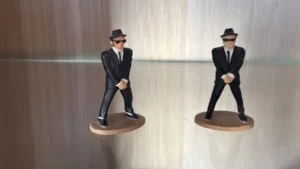 Retrouvez Jake et Elwood dans toute leur élégance avec ce superbe lot de deux figurines Blues Brothers produites par Corgi. Ces deux personnages emblématiques sont fidèlement reproduits dans leur célèbre costume noir, lunettes sombres et chapeau, prêts à entrer en scène pour une nouvelle mission "au service de Dieu". Caractéristiques : 🧍‍♂️ Figurines en résine peinte 🎩 Détails soignés : lunettes, cravate, costume 📏 Hauteur approximative : 7 cm 🧱 Socle estampillé Corgi 📦 Vendu en lot de 2 🔍 État : très bon état Figurines Blues Brothers Corgi – Lot de 2 personnages